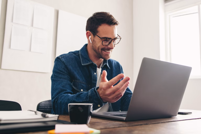 Happy businessman speaking with his team on a video call
